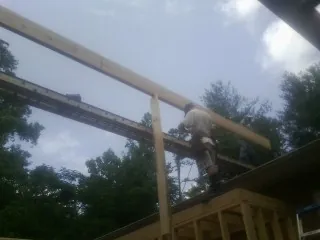 Carpenter setting a ridge beam over a new addition frame — Ice Dam Removal by Roofing Brothers in Wrightwood