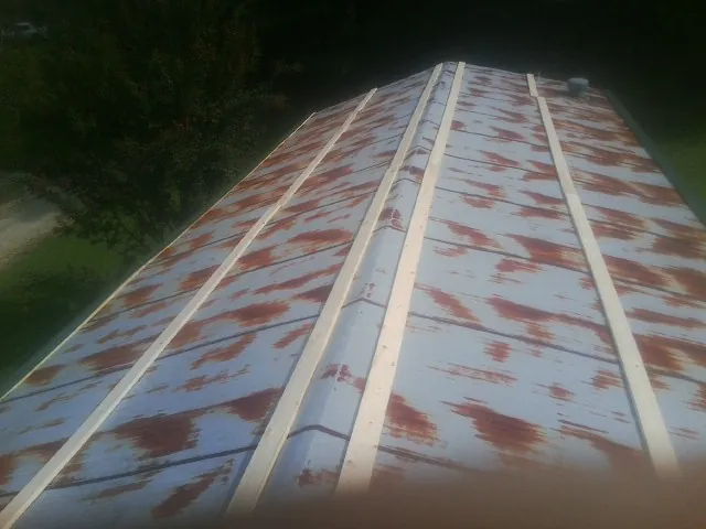 Rusted metal roof panels with new wood purlins before replacement — Storm Damage Roof Repair in Wrightwood by Roofing Brothers